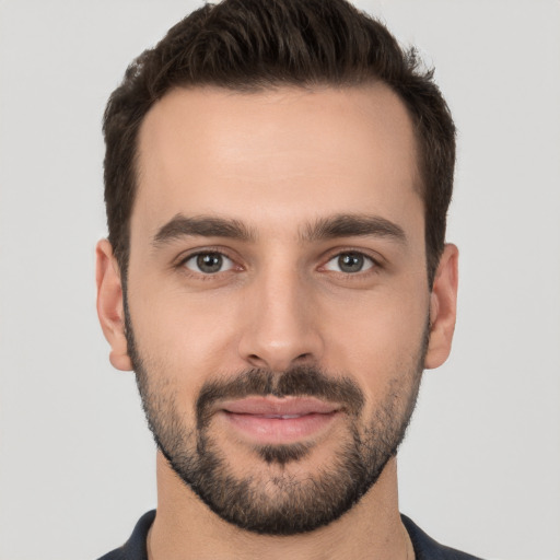 Joyful white young-adult male with short  black hair and brown eyes