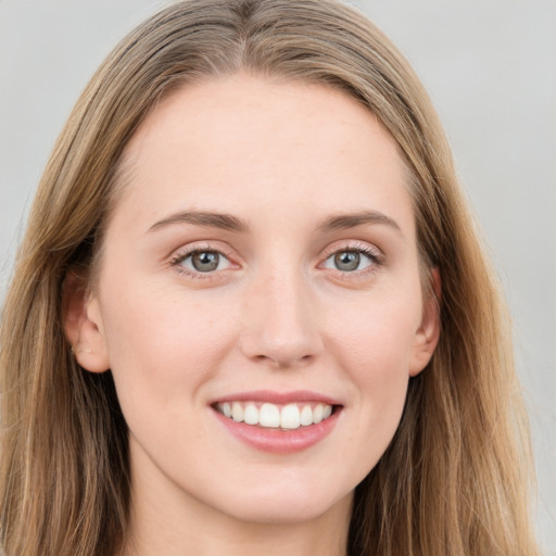 Joyful white young-adult female with long  brown hair and blue eyes