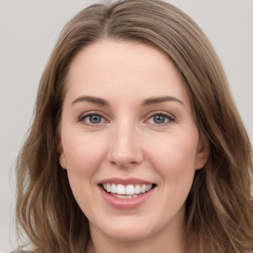 Joyful white young-adult female with long  brown hair and grey eyes