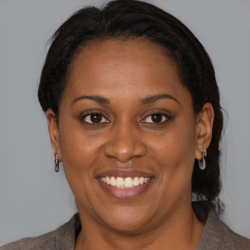 Joyful black young-adult female with medium  brown hair and brown eyes