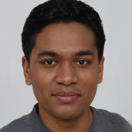Joyful black young-adult male with short  black hair and brown eyes