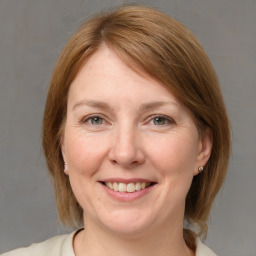 Joyful white adult female with medium  brown hair and blue eyes