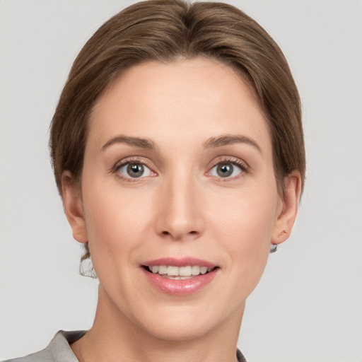 Joyful white young-adult female with short  brown hair and grey eyes