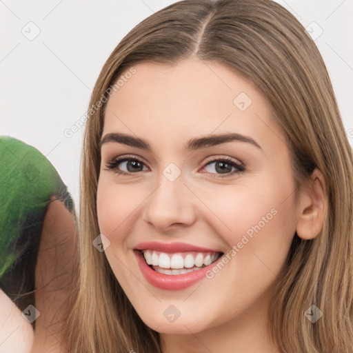 Joyful white young-adult female with long  brown hair and brown eyes