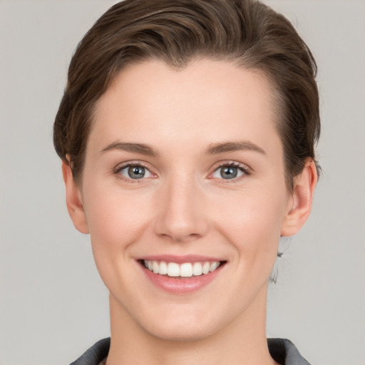 Joyful white young-adult female with short  brown hair and grey eyes