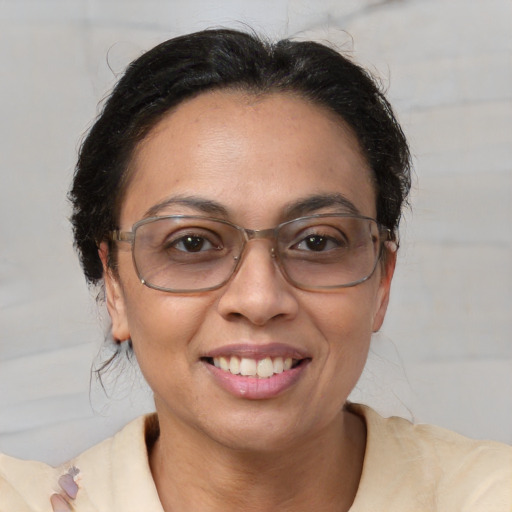 Joyful latino adult female with medium  brown hair and brown eyes