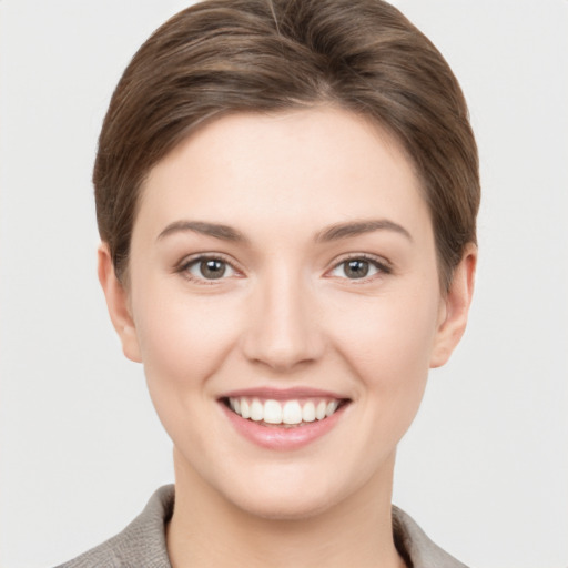 Joyful white young-adult female with short  brown hair and grey eyes