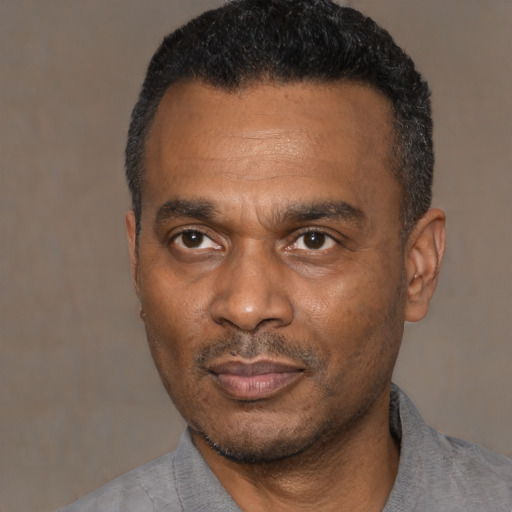 Joyful black adult male with short  black hair and brown eyes