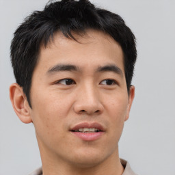 Joyful asian young-adult male with short  brown hair and brown eyes