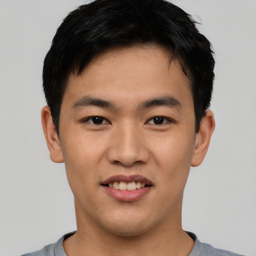Joyful asian young-adult male with short  brown hair and brown eyes