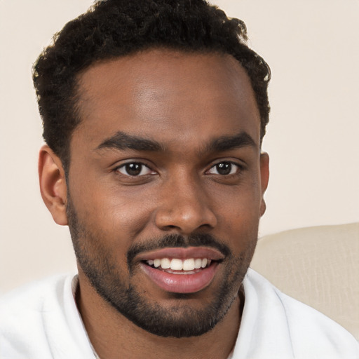 Joyful black young-adult male with short  brown hair and brown eyes