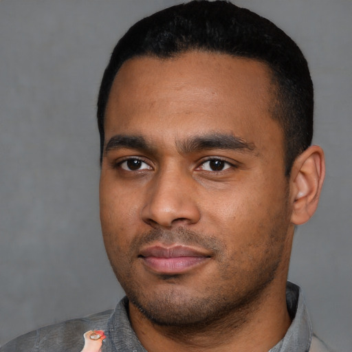 Joyful black young-adult male with short  black hair and brown eyes