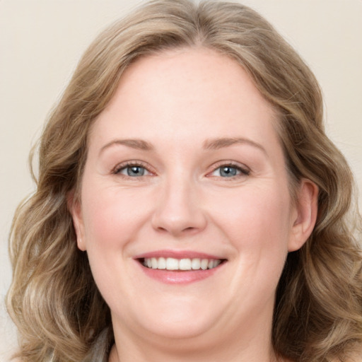 Joyful white adult female with long  brown hair and blue eyes