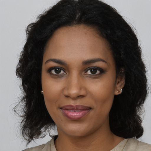Joyful black young-adult female with long  brown hair and brown eyes