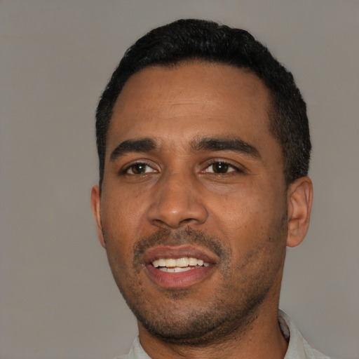 Joyful black young-adult male with short  black hair and brown eyes