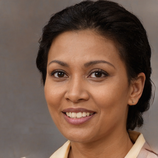 Joyful latino adult female with medium  brown hair and brown eyes