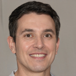 Joyful white adult male with short  brown hair and brown eyes