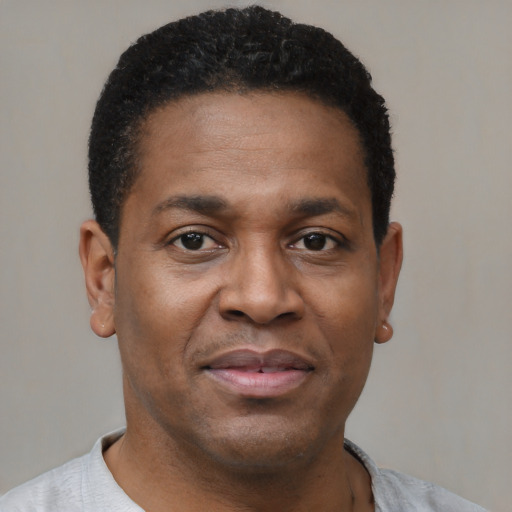 Joyful black young-adult male with short  brown hair and brown eyes