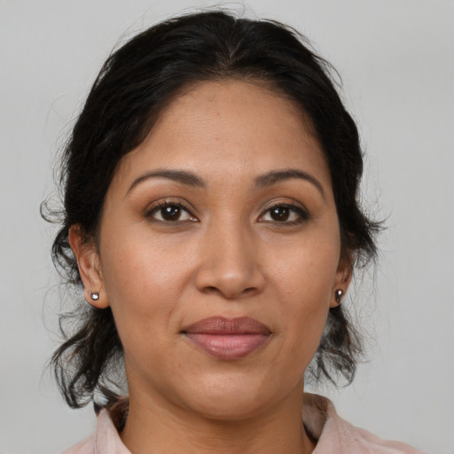 Joyful latino adult female with medium  brown hair and brown eyes