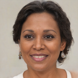 Joyful black adult female with medium  brown hair and brown eyes