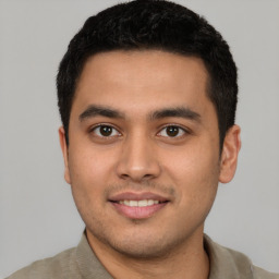 Joyful latino young-adult male with short  black hair and brown eyes