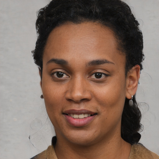 Joyful black young-adult female with short  black hair and brown eyes