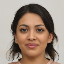 Joyful latino young-adult female with medium  brown hair and brown eyes