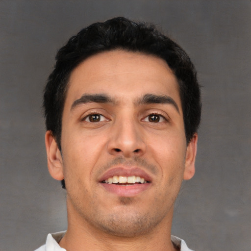 Joyful white young-adult male with short  black hair and brown eyes