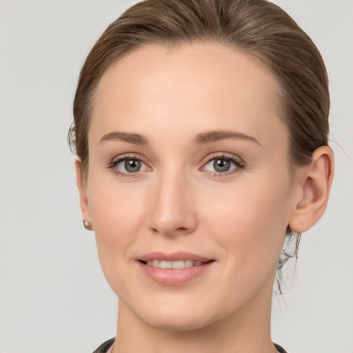 Joyful white young-adult female with medium  brown hair and grey eyes