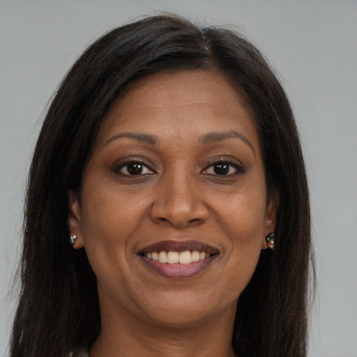 Joyful black adult female with long  brown hair and brown eyes