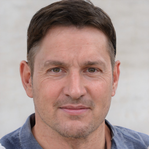 Joyful white adult male with short  brown hair and grey eyes