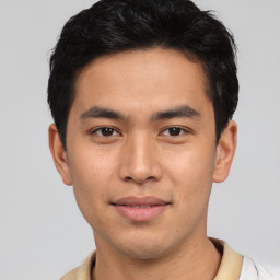 Joyful asian young-adult male with short  brown hair and brown eyes