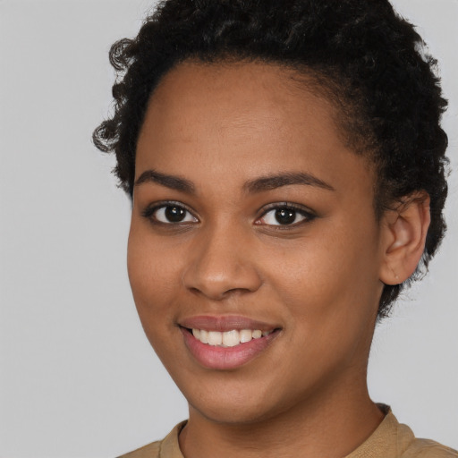 Joyful black young-adult female with short  brown hair and brown eyes