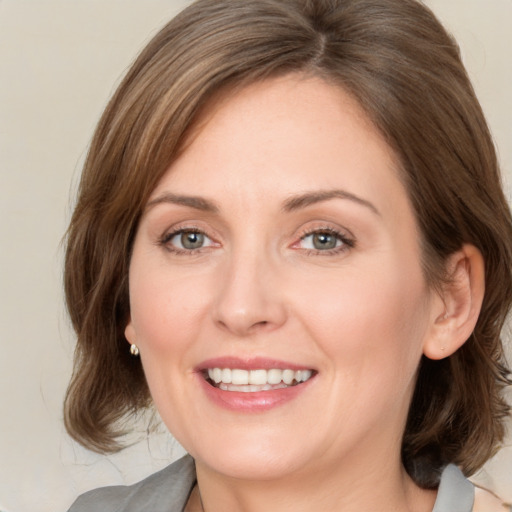 Joyful white young-adult female with medium  brown hair and green eyes