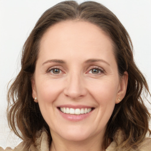 Joyful white young-adult female with medium  brown hair and green eyes