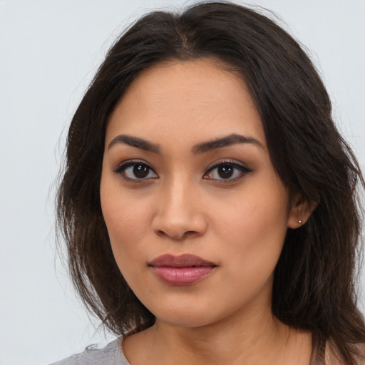 Joyful latino young-adult female with long  brown hair and brown eyes