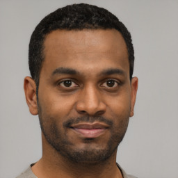 Joyful latino young-adult male with short  black hair and brown eyes