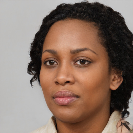 Joyful black young-adult female with medium  black hair and brown eyes