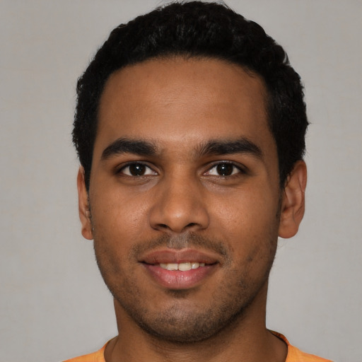 Joyful black young-adult male with short  black hair and brown eyes