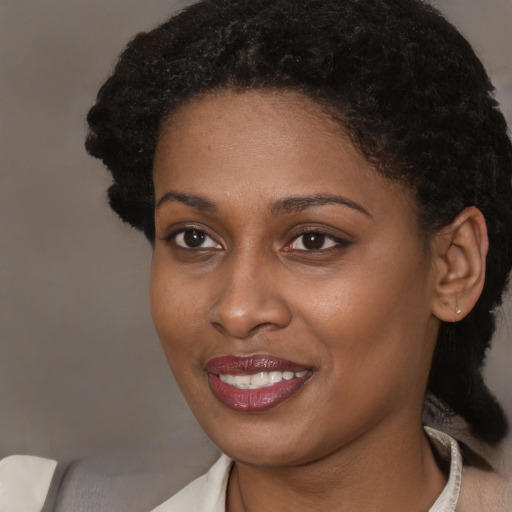 Joyful black young-adult female with short  brown hair and brown eyes