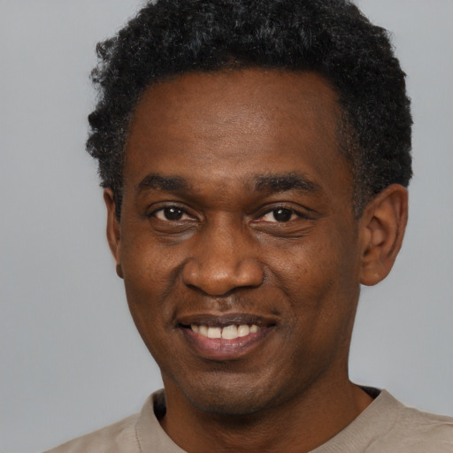 Joyful black young-adult male with short  black hair and brown eyes
