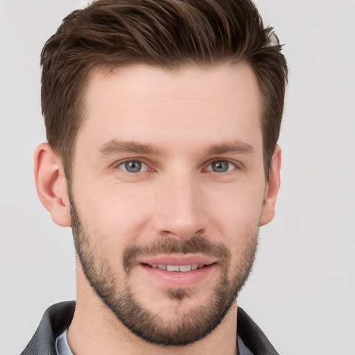 Joyful white young-adult male with short  brown hair and grey eyes