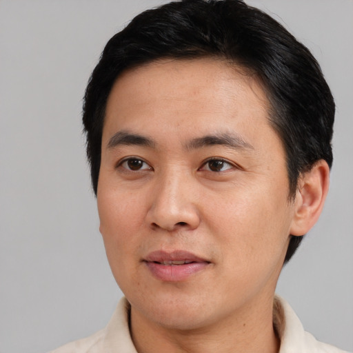 Joyful asian adult male with short  black hair and brown eyes