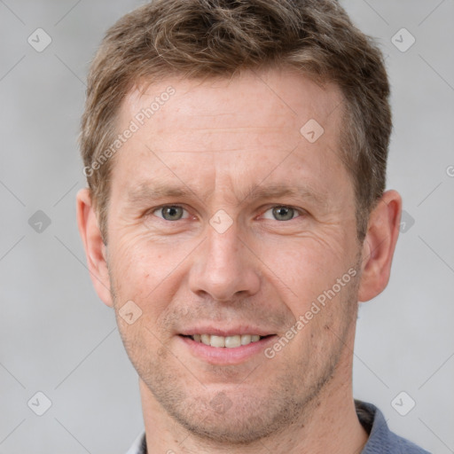 Joyful white adult male with short  brown hair and grey eyes