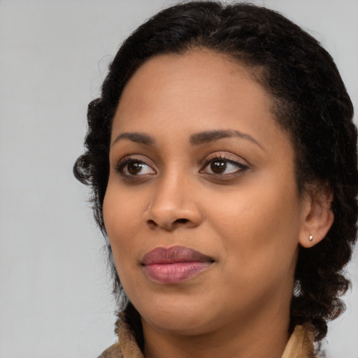 Joyful black young-adult female with medium  black hair and brown eyes