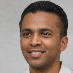 Joyful latino young-adult male with short  black hair and brown eyes