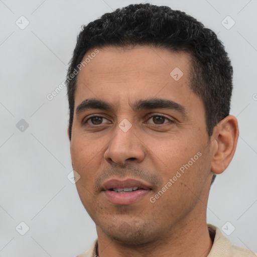 Joyful latino young-adult male with short  black hair and brown eyes