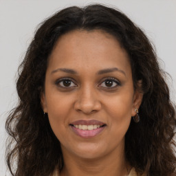 Joyful black adult female with long  brown hair and brown eyes