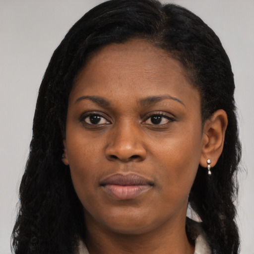 Joyful black young-adult female with long  black hair and brown eyes