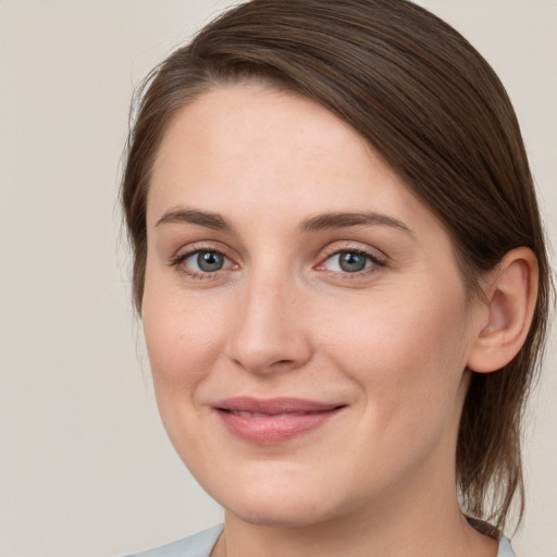 Joyful white young-adult female with medium  brown hair and grey eyes